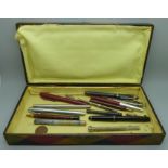 A collection of pens and pencils including a silver pencil