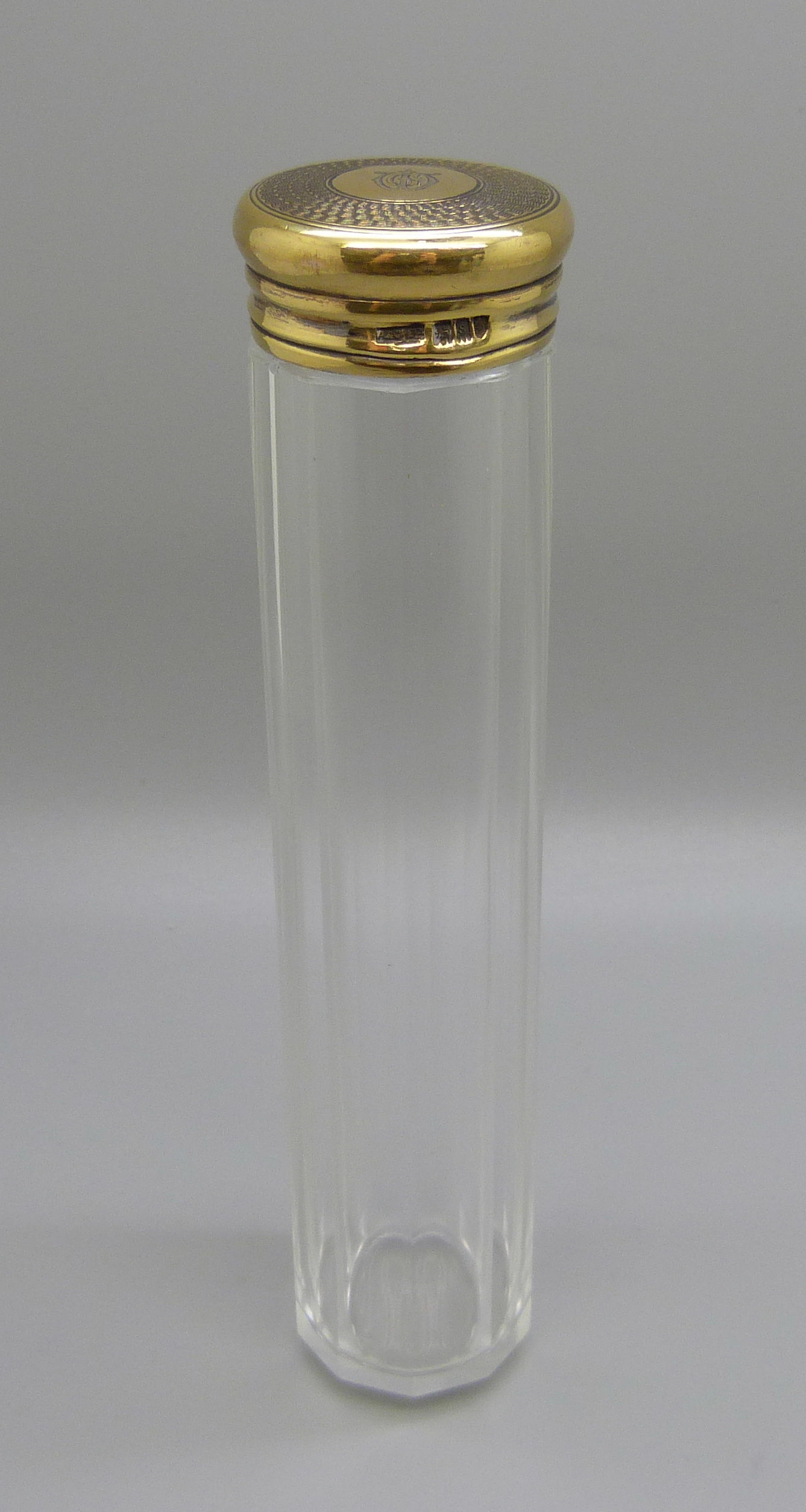 A glass bottle with a sterling silver lid hallmarked for Asprey of London, date letter for London