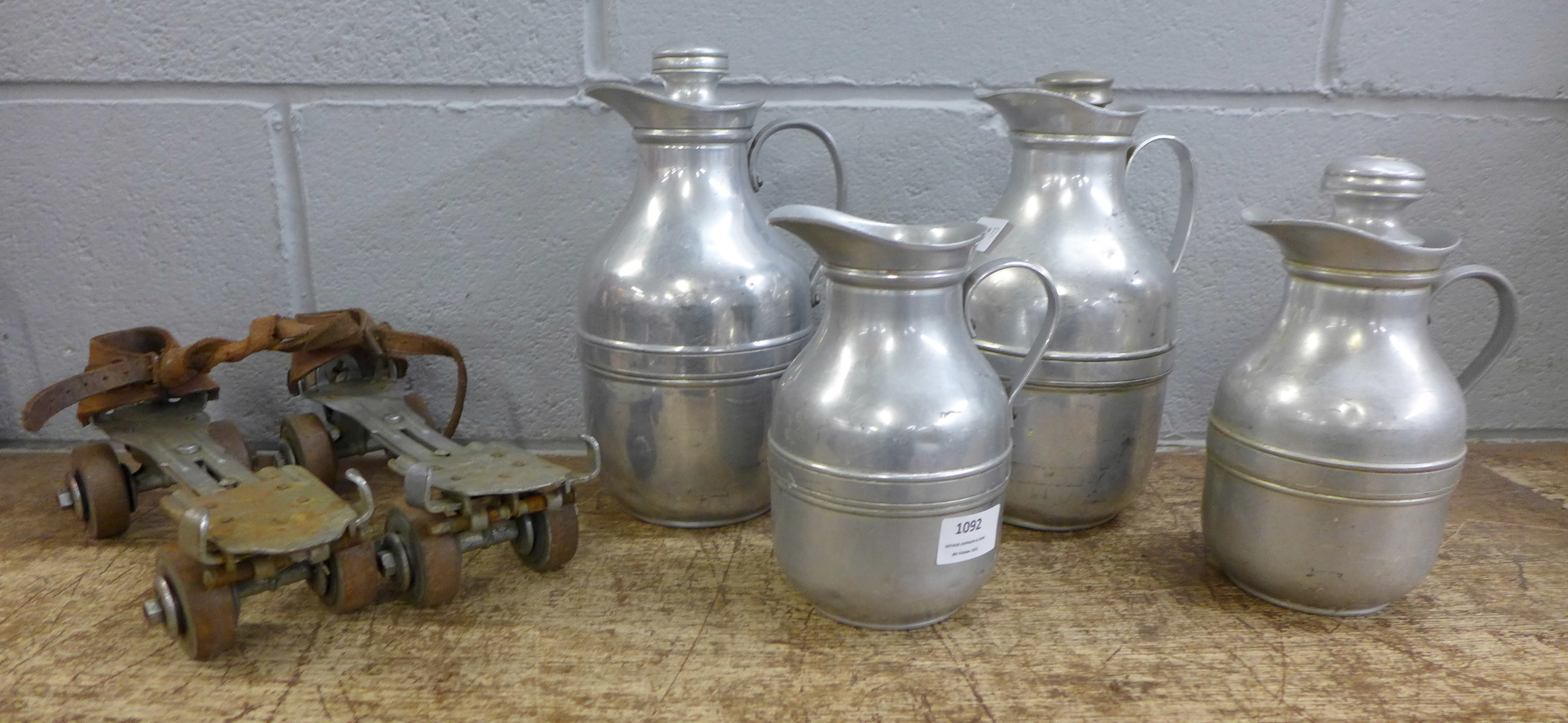 Four early Thermos flasks, one lacking stopper and a pair of early roller skates