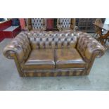 A chestnut brown leather Chesterfield settee