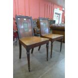 A pair of George III painted mahogany armorial hall chairs