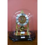 A glass domed gilt metal six spoke fusee skeleton clock, on ebonised stand