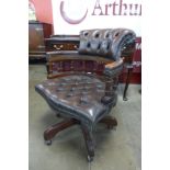 A mahogany and brown leather revolving Captain's desk chair