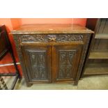 A Victorian Jacobean Revival carved oak green man cupboard