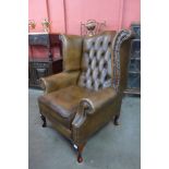 A chestnut brown leather Chesterfield wingback armchair