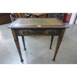 An Arts and Crafts oak and green leather topped single drawer writing table