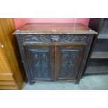 A Victorian Jacobean Revival carved oak green man cupboard