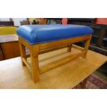 A Cotswold School Arts and Crafts oak and blue vinyl upholstered foot stool