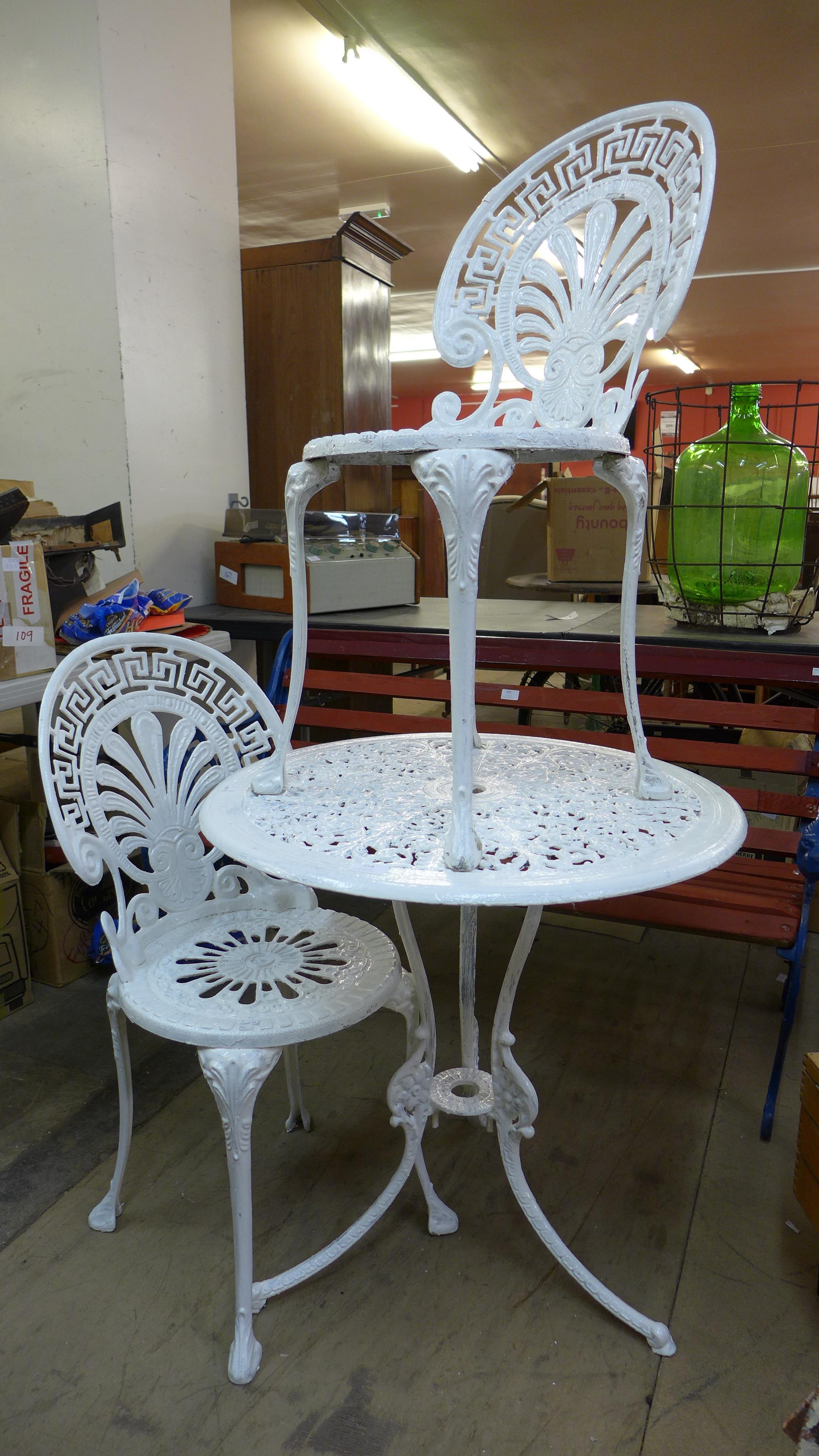 A painted cast alloy garden table and two chairs