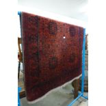 A small eastern hand knotted red ground rug, 192 x 130cms