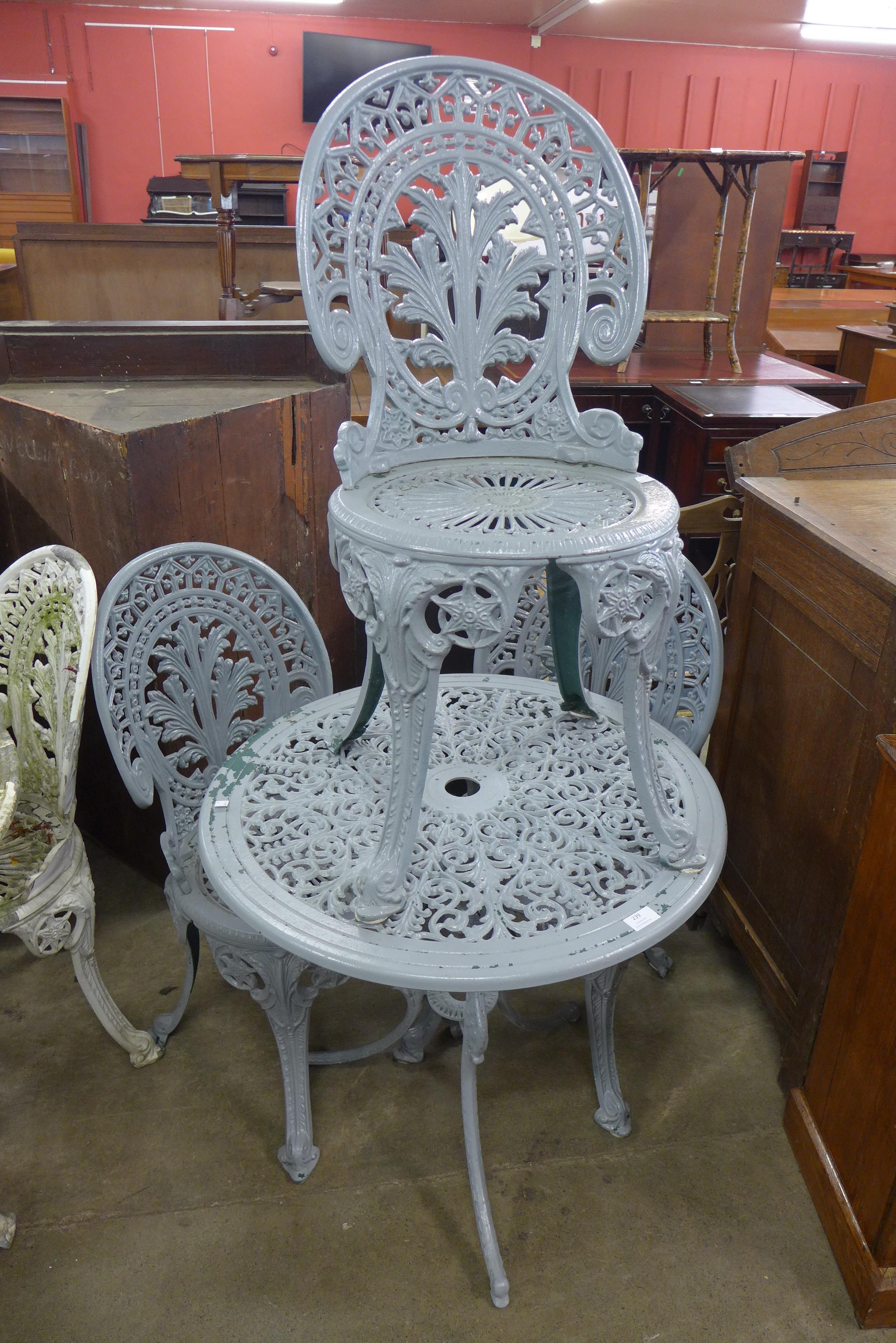 A painted cast aluminium garden table and three chairs