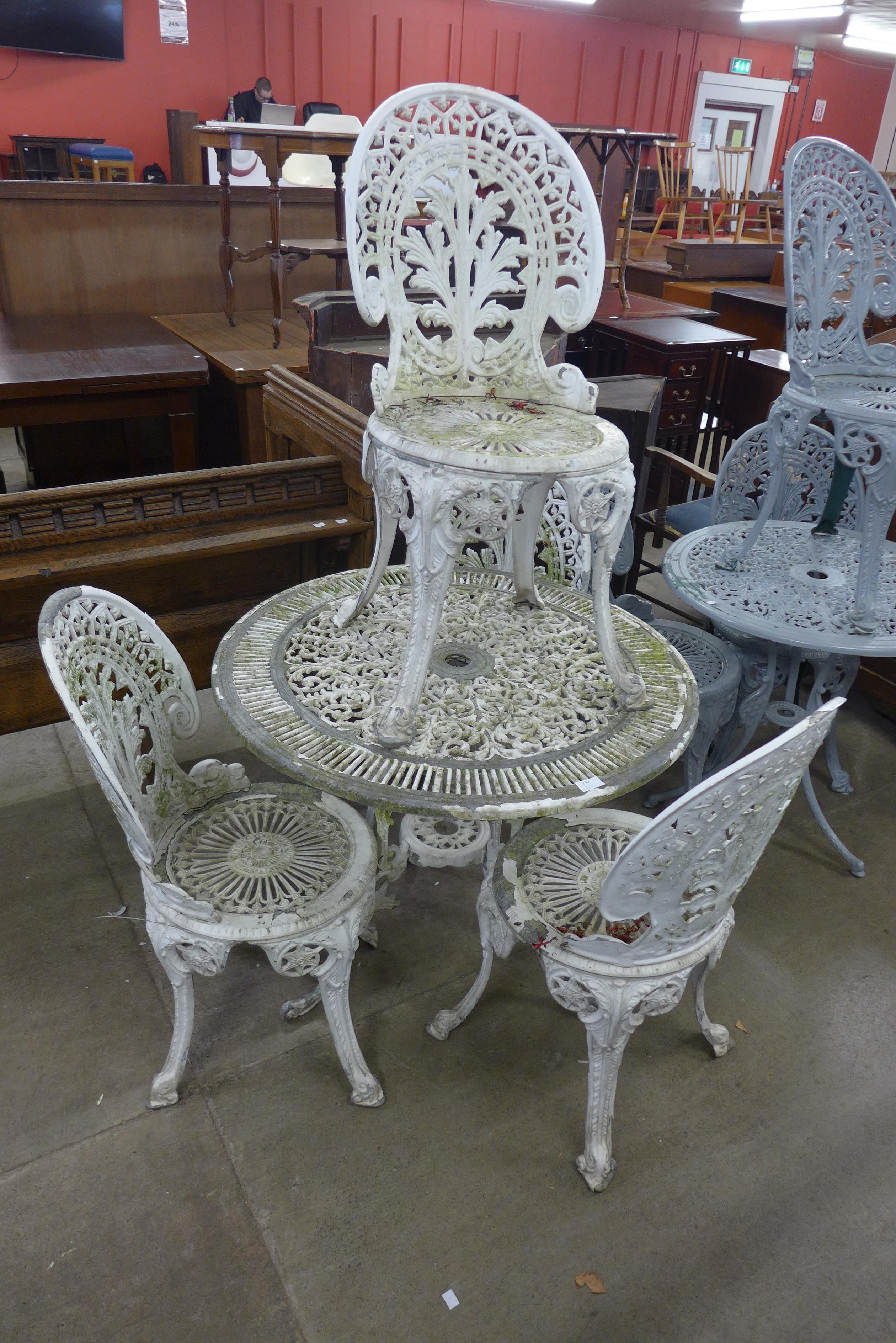 A painted cast aluminium garden table and four chairs