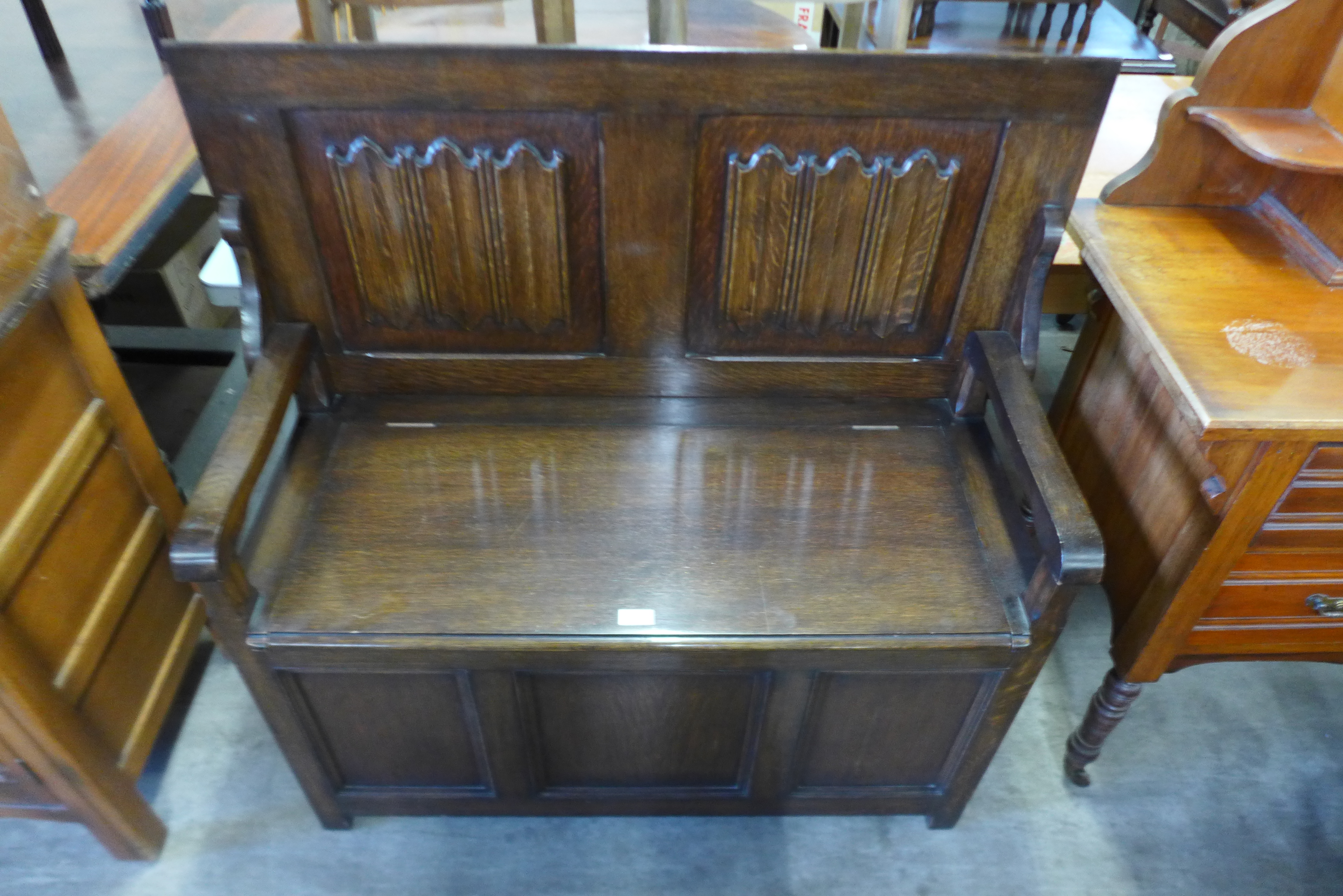 A carved oak linenfold monks bench