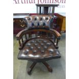 A mahogany and brown leather revolving Captain's desk chair