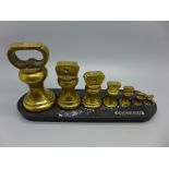 A graduated set of Victor England brass weights and stand