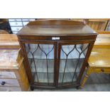 An oak bow front display cabinet