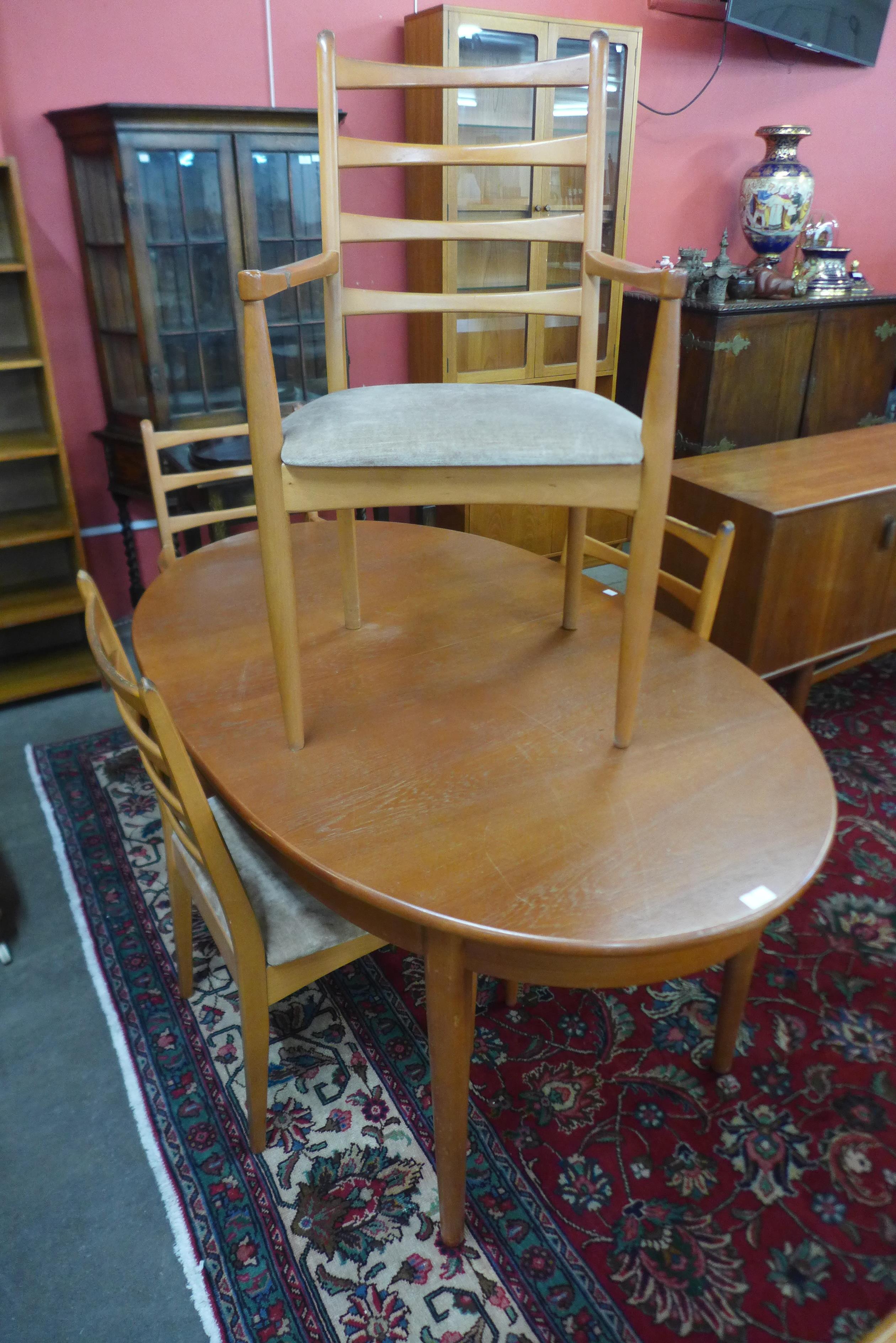 A teak extending dining table and four chairs