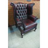 An oxblood red leather wingback armchair