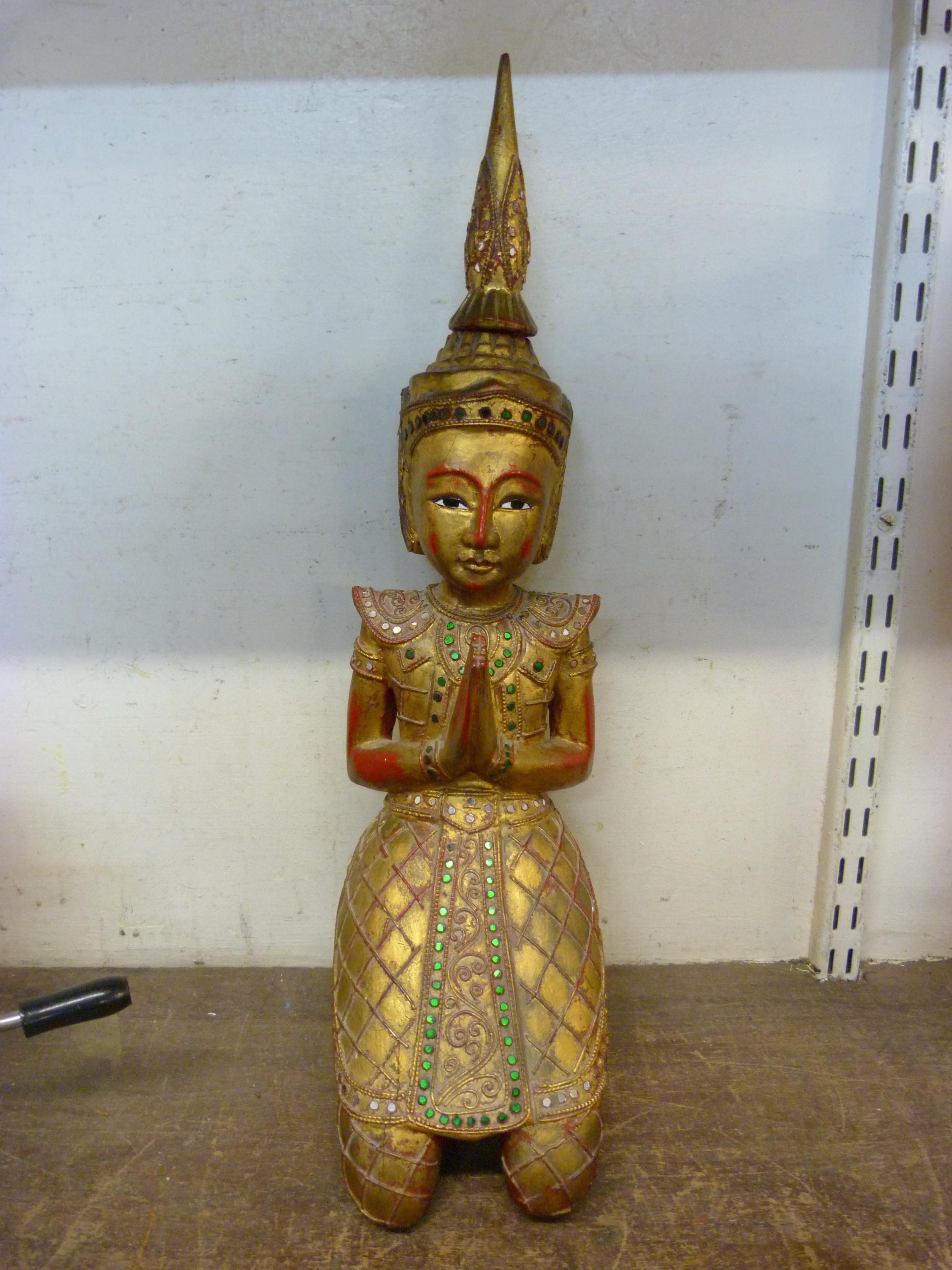 An oriental gilt wood figure of a seated diety