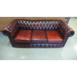 An oxblood red leather Chesterfield settee