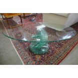 A contemporary oval glass coffee table on spiral base