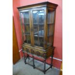 An early 20th Century Jacobean Revival oak side cabinet on stand