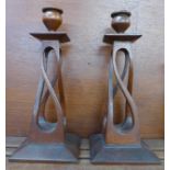 A pair of Arts and Crafts carved oak candlesticks, 26cm