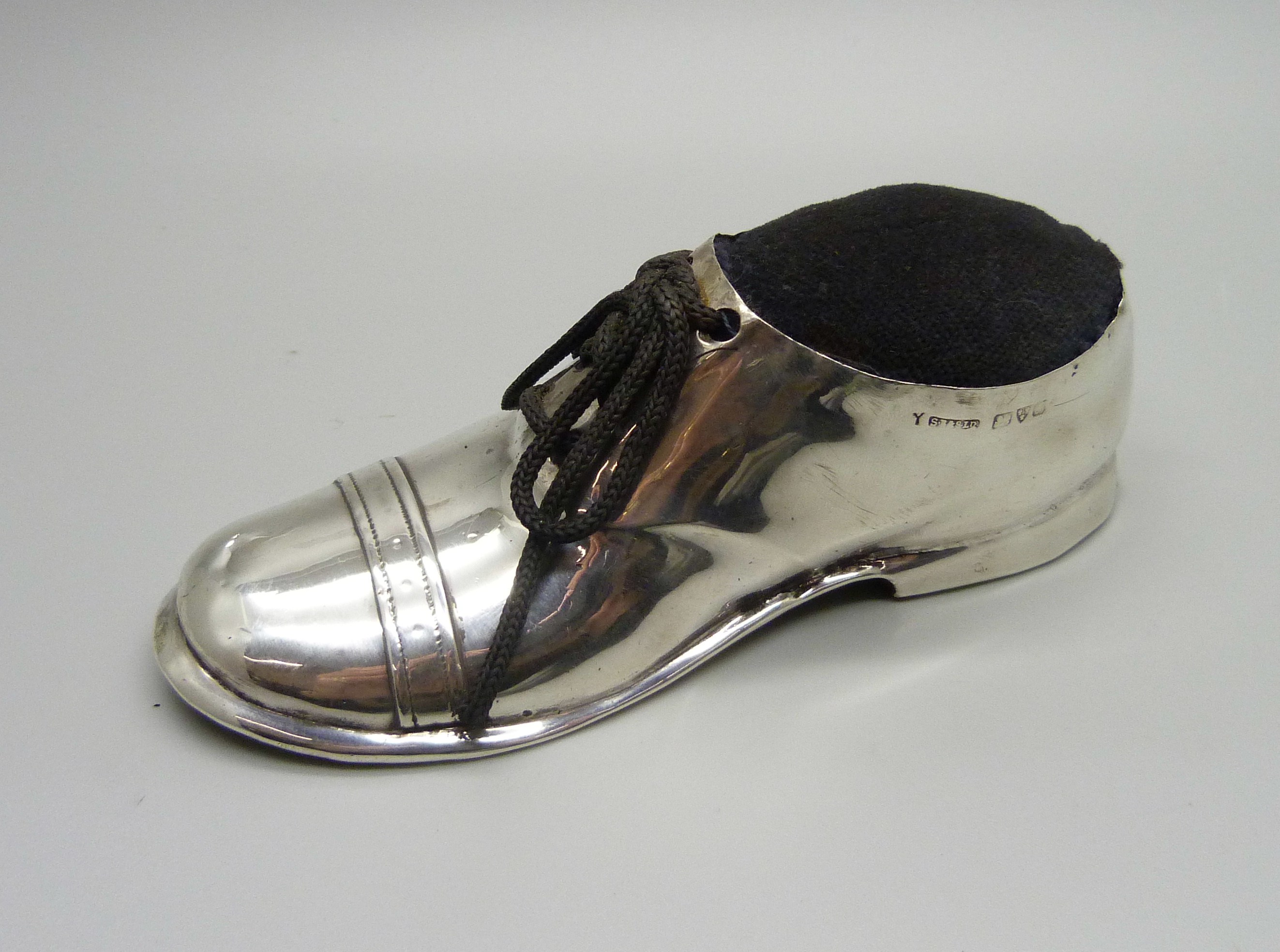 A novelty silver shoe pin cushion, worn Chester hallmark, 12cm