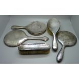 Two silver backed hand mirrors, two silver backed brushes and a silver mirror back