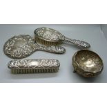 A silver backed mirror and two brushes and a white metal and enamel pot