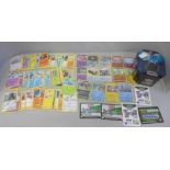 A Pokemon collectors tin containing four rare holographic cards with protective sleeves, ten reverse