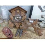 A wooden cuckoo clock and a wooden mask