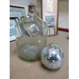 A small mirrored disco ball and a glass carboy