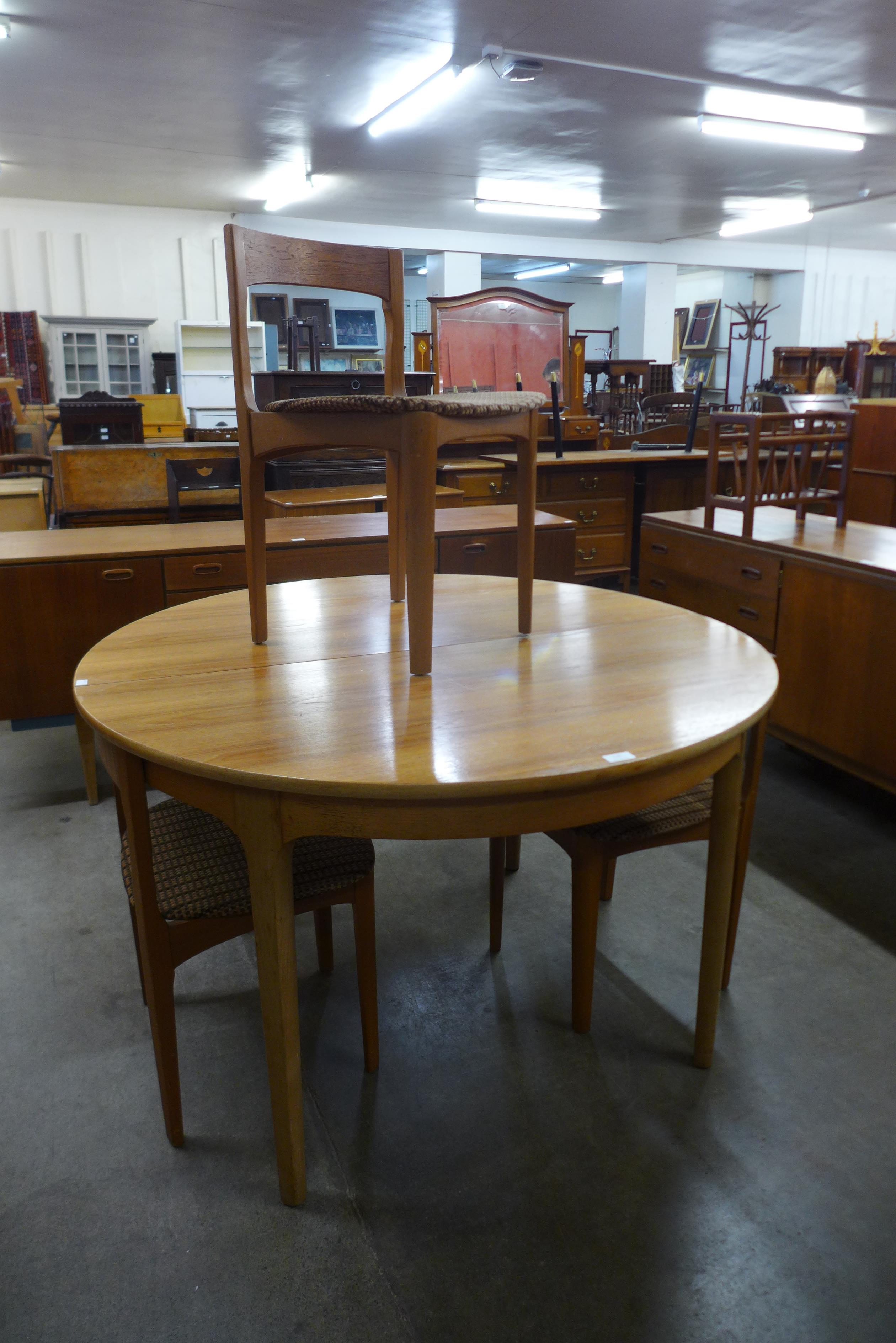 A Nathan teak circular extending dining table and three chairs