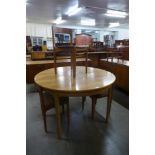 A Nathan teak circular extending dining table and three chairs