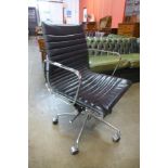 An Eames style chrome and black leather revolving desk chair