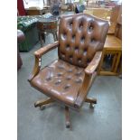 A mahogany and tan leather revolving desk chair