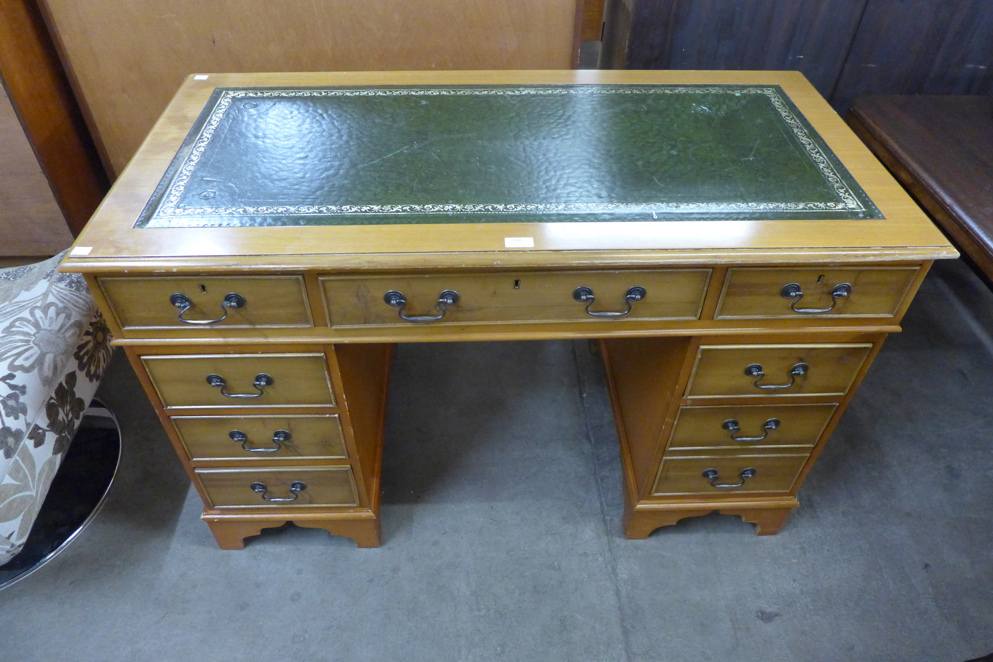 A yew wood and green leather topped pedestal desk