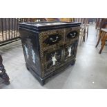 A small Japanese black chinoiserie lacquered cupboard