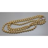 A pearl necklace with yellow metal and hand painted clasp