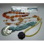 An agate necklace and one other, a Paua shell and blue stone necklace, a carved black stone flower