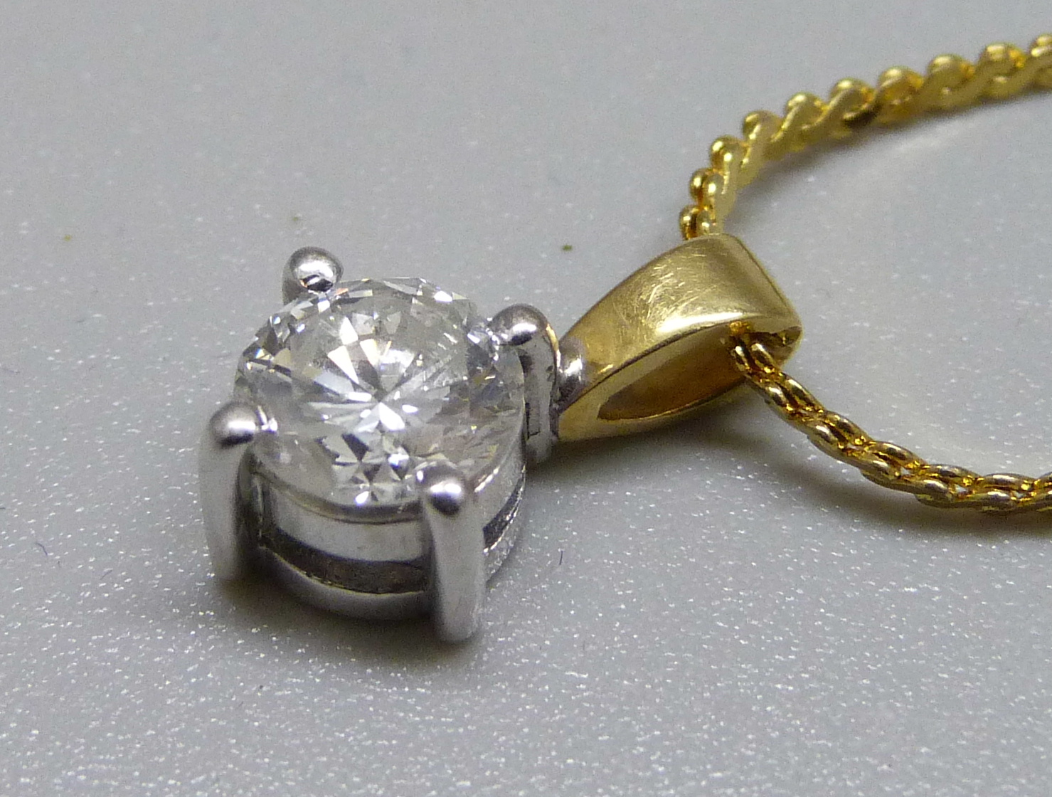 An 18ct gold and diamond pendant, approximately 0.90ct diamond weight, on a plated chain