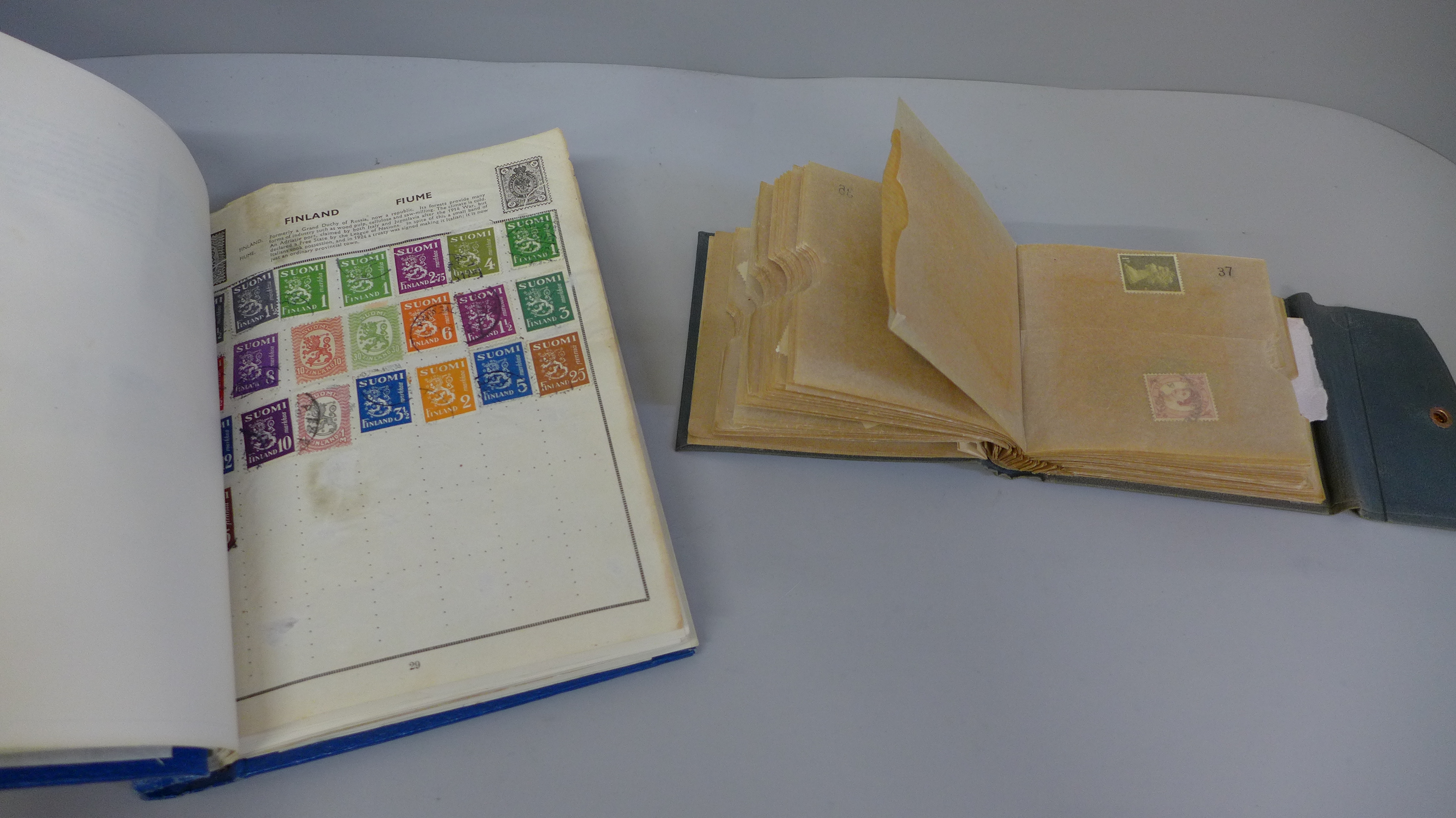 A stamp album containing world stamps and another book of loose stamps