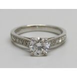 A platinum, brilliant cut diamond solitaire ring with diamond shoulders, diamond measures 0.8cts