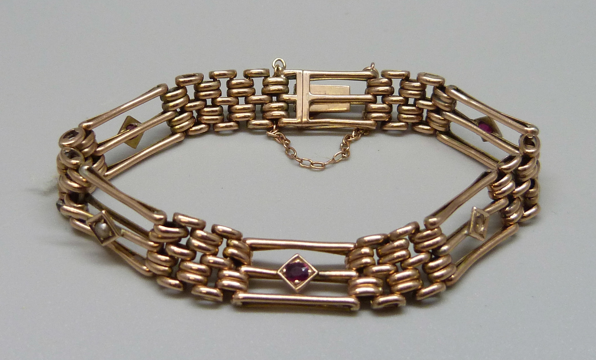 A 9ct gold and garnet bracelet, 14.2g, one seed pearl missing