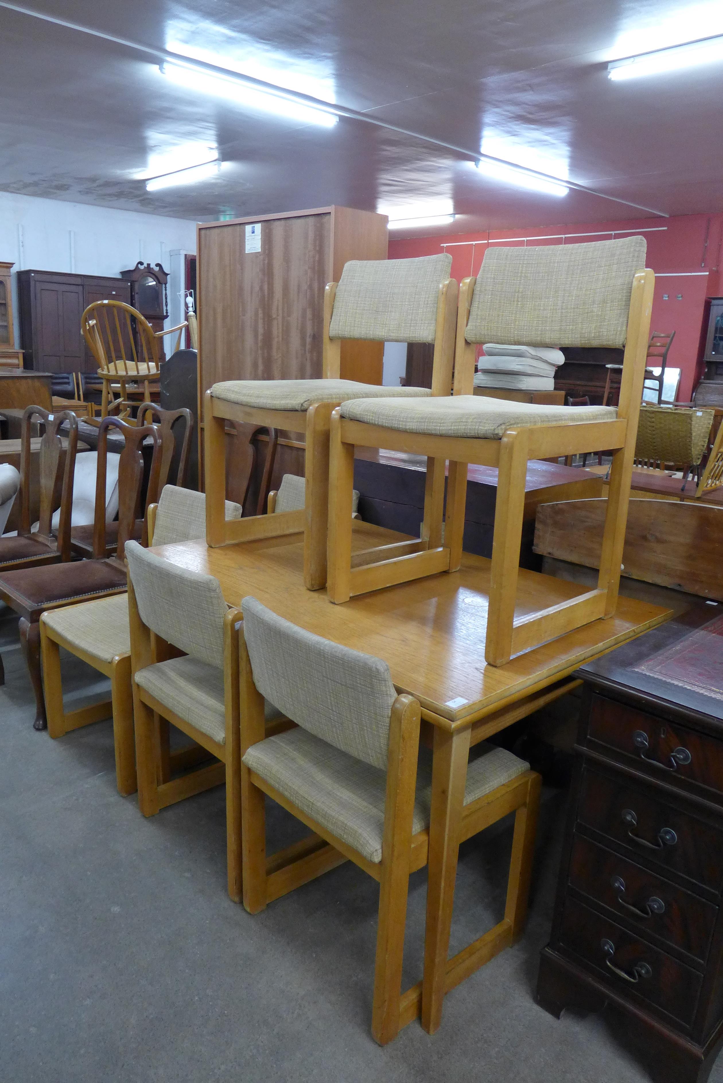 A teak extending table and six chairs