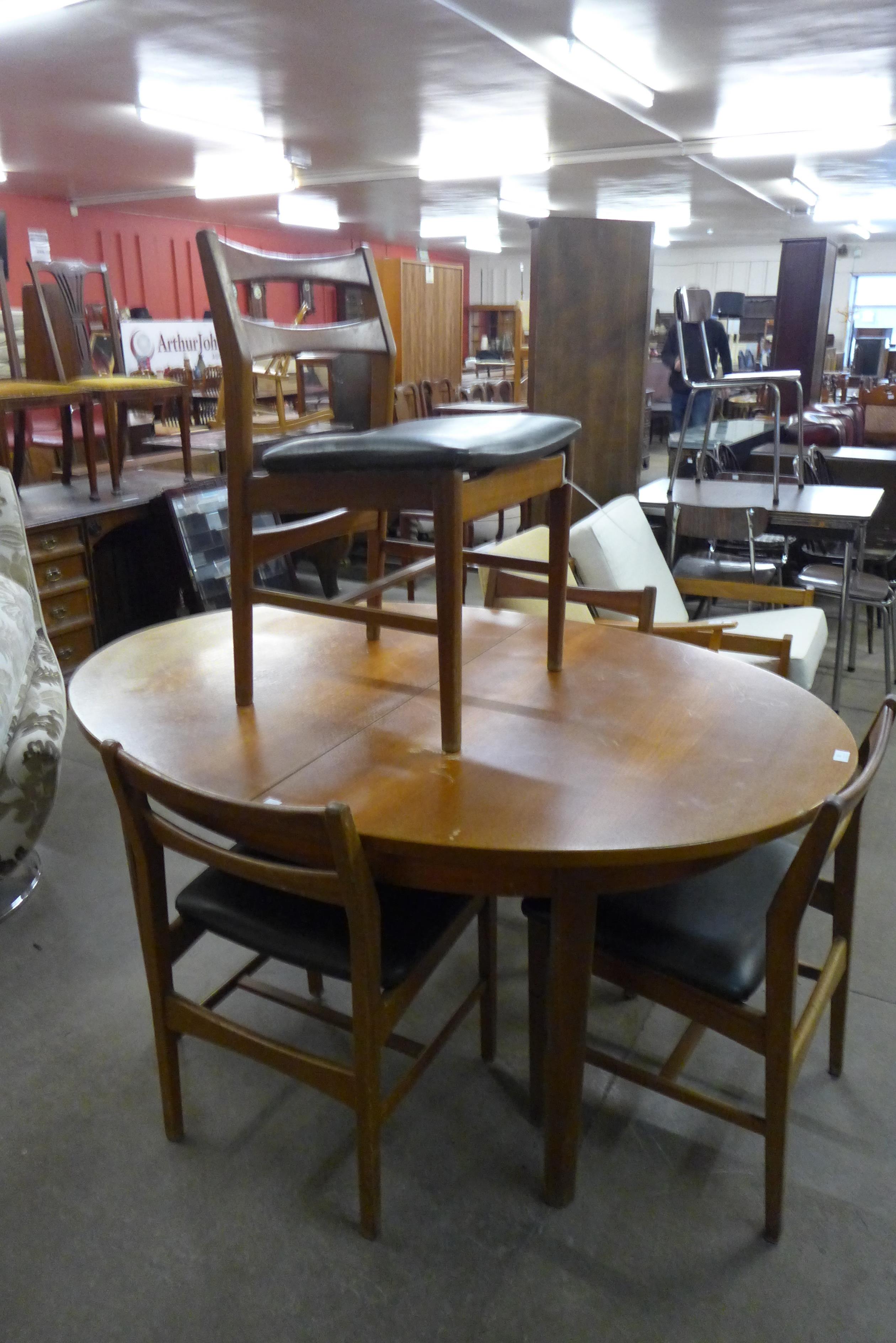 A teak extending dining table and four chairs