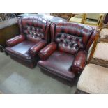 A pair of red leather buttoned back armchairs