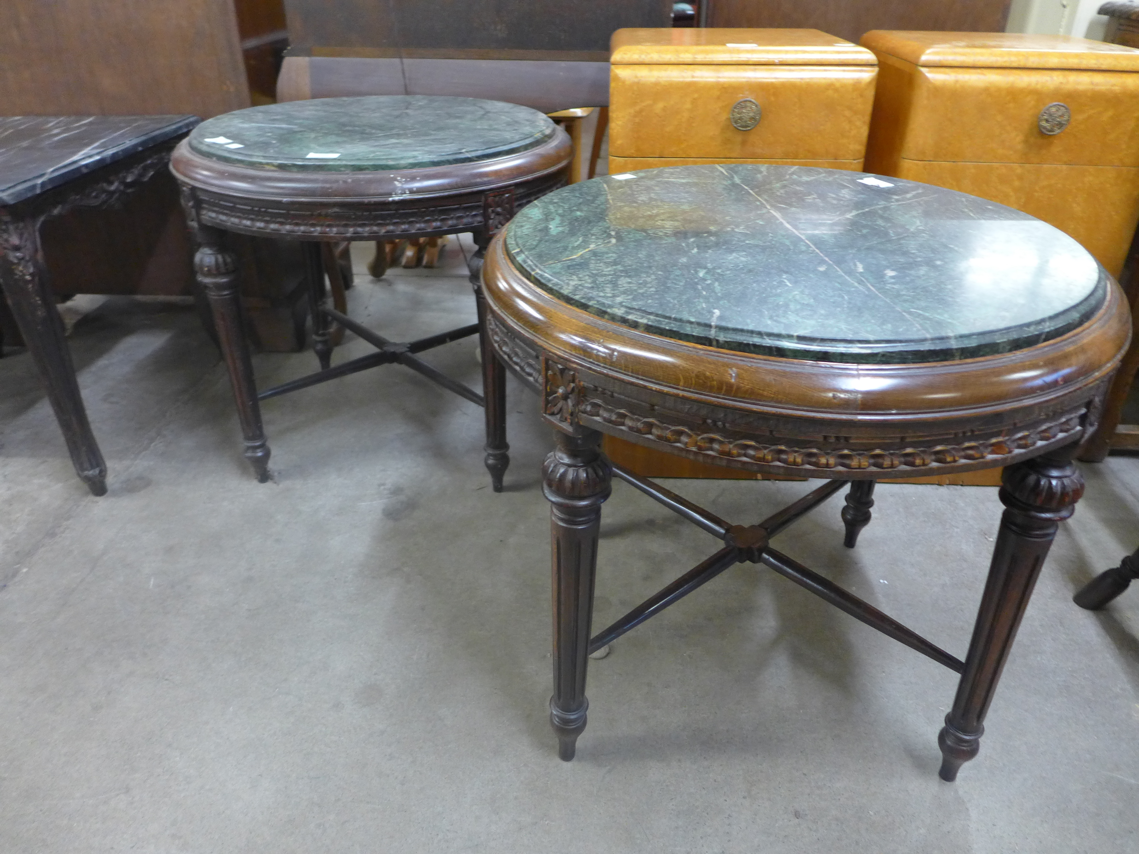 A pair of French style circular beech and marble topped lamp tables