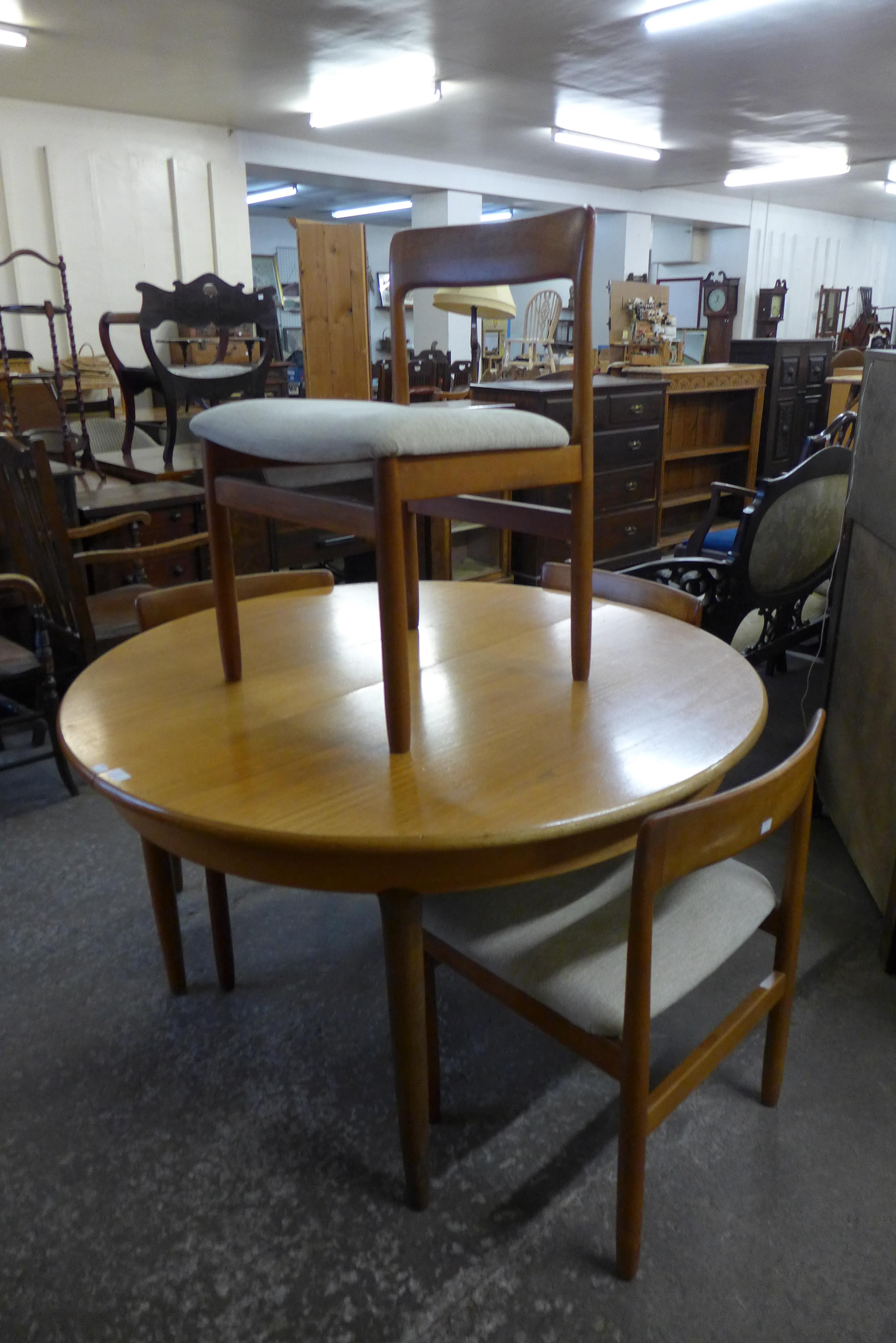 A teak extending dining table and four chairs